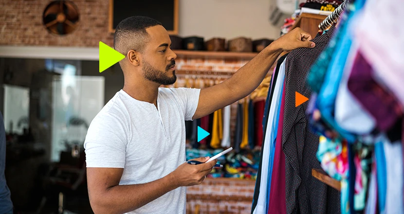como precificar roupas: homem em loja vendo camisas