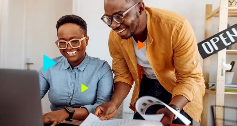 Orçamento Flexível: pessoas sorrindo a frente de notebook e folhas